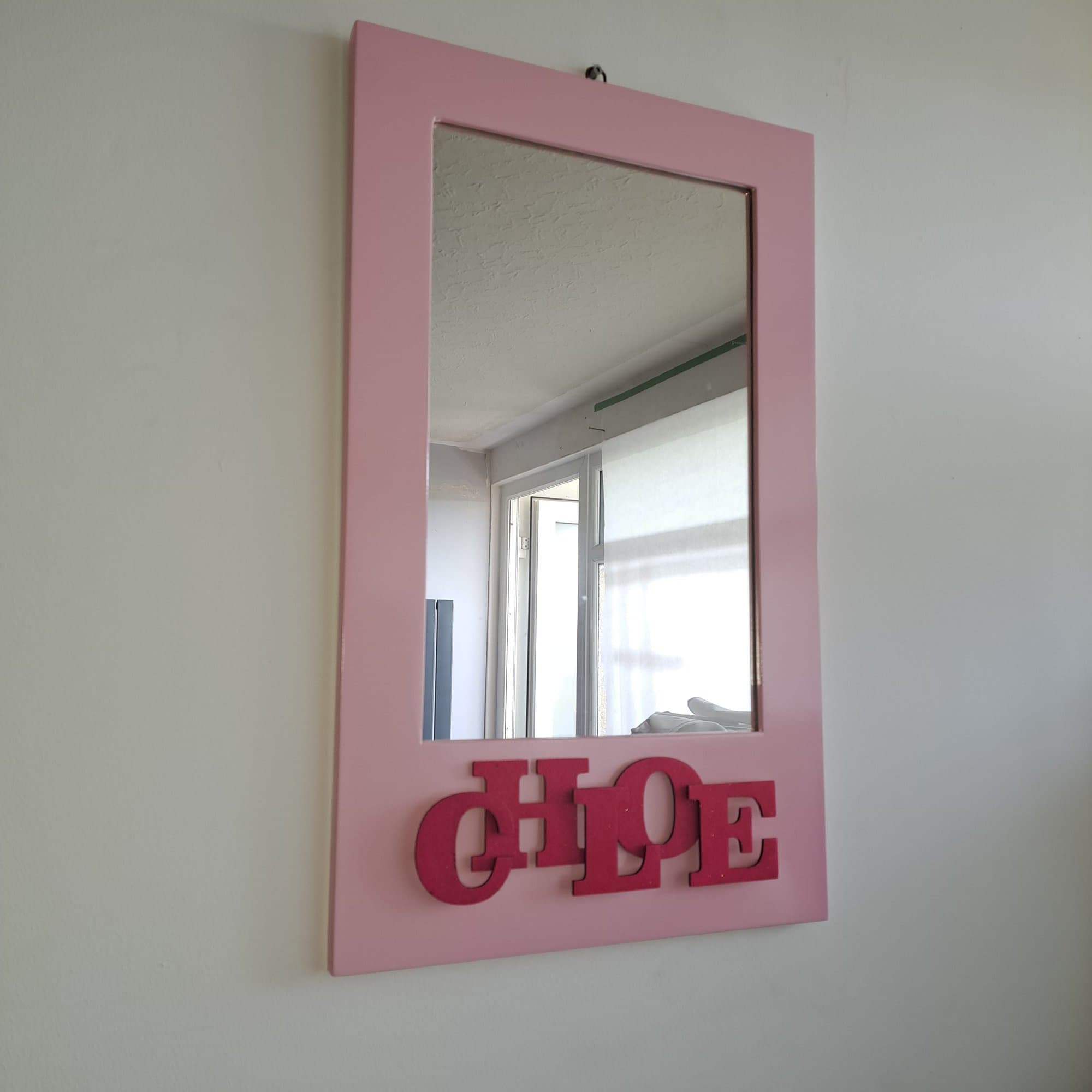 Pink mirror frame with the name Chloe cut out and mounted on it