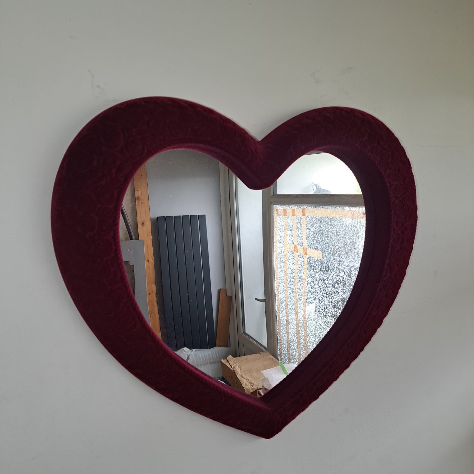 Heart shaped mirror with a deep red flocked frame