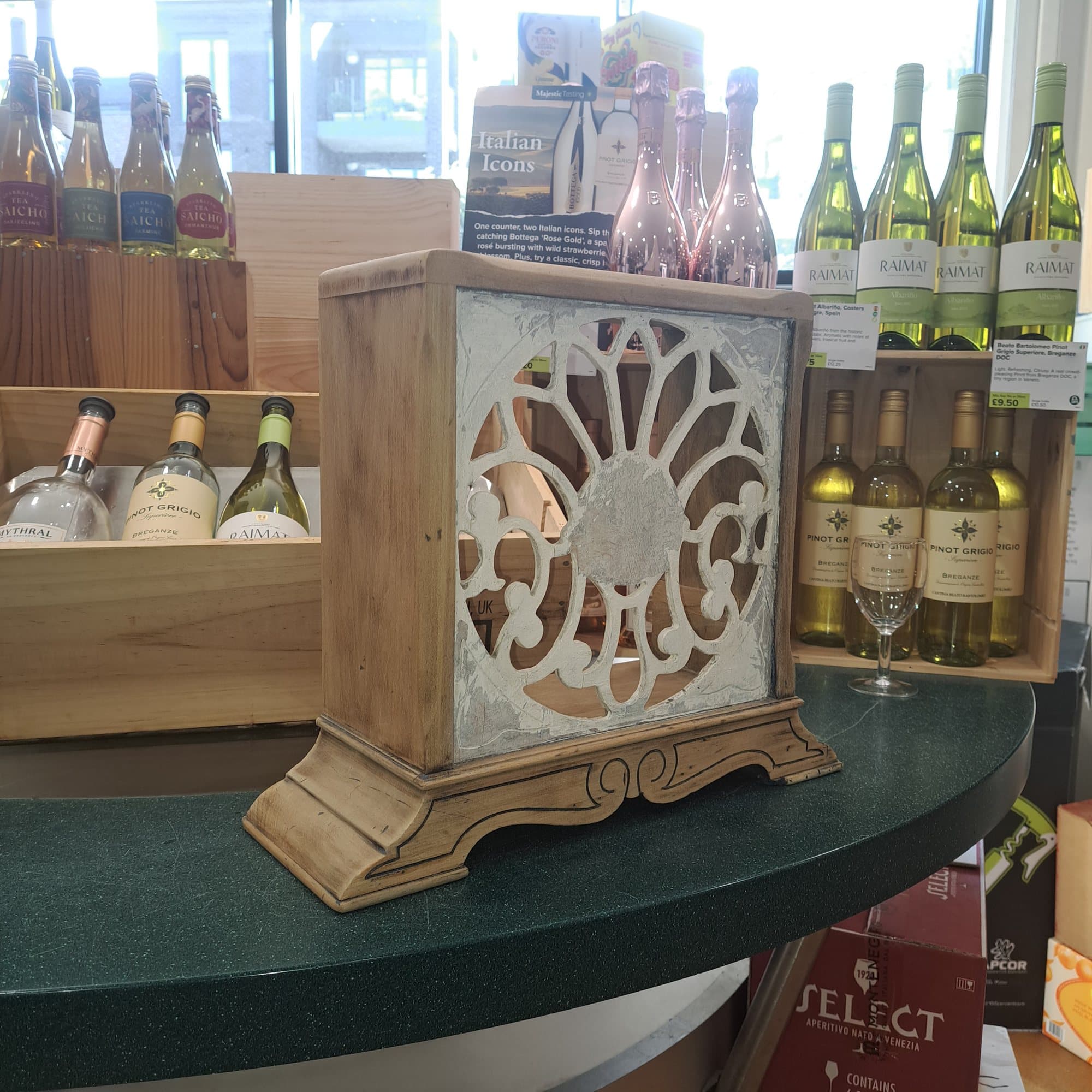 Timber cabinet with a carved fretwork front, on a wine shop counter