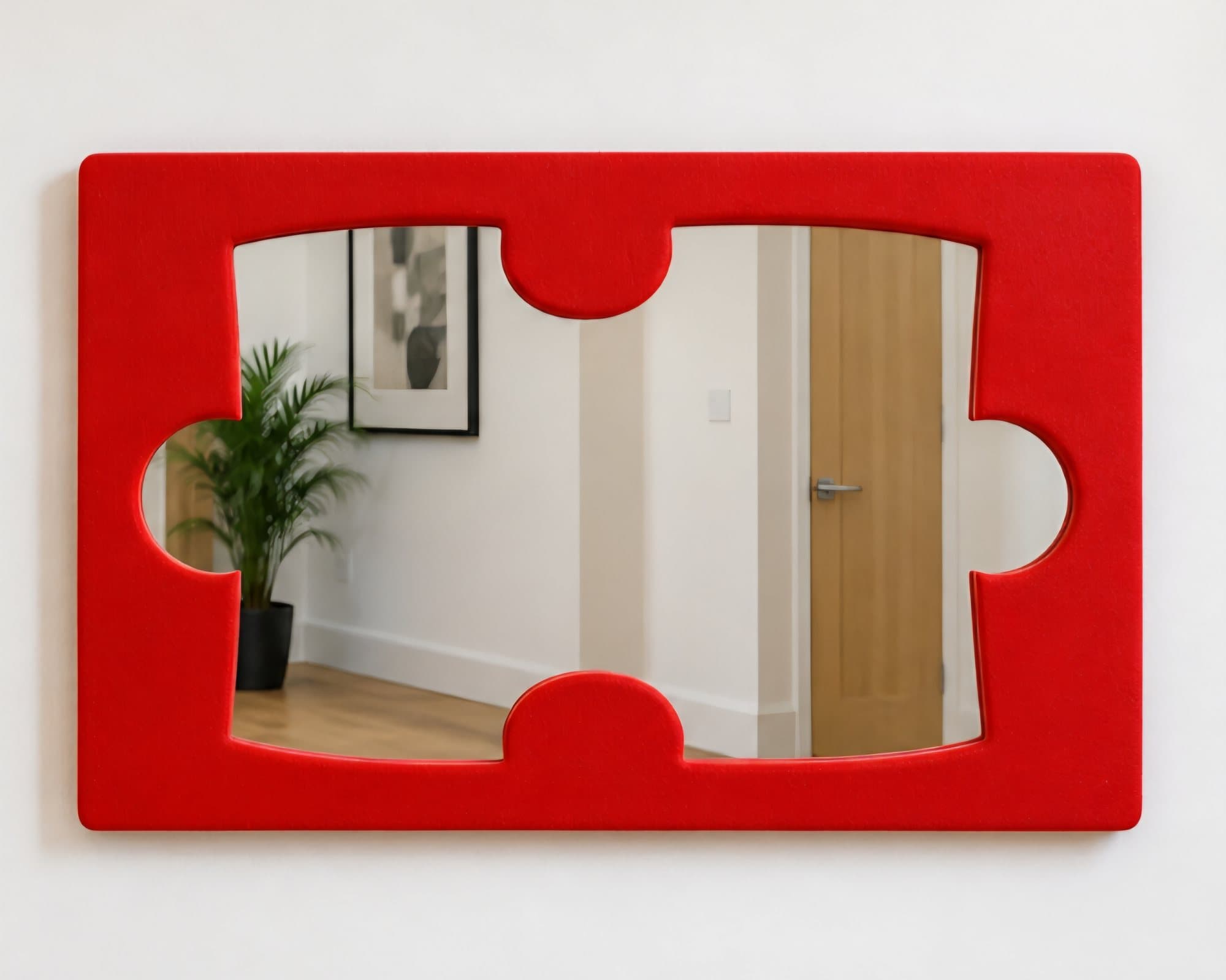 Wide red jigsaw piece mirror on a white hallway wall